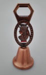 Sineta/abridor de garrafas  em metal cobreado; com bandeira e fisionomia e rosto representando o Egito. Medindo 11 cm de altura .
