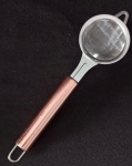 Peneira / coador de inox com cabo rose . Medida total : 22,5 cm / Medida da peneira : 3 x 6 cm.