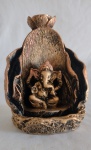 Incensário em resina com policromia dourada, representando uma gruta formada por folhas, tendo a imagem de Ganesha. Medindo 12 cm de altura.