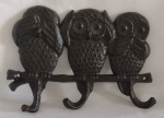 Aplique para parede em ferro fundido, com 3 ganchos representando corujas como os macacos sábios Não vejo, não ouço e não falou. Medindo 24 x 15 cm.