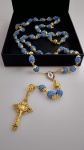 Belissimo Terço na cor dourado ; todo cravejado com pedrinhas brilhantes na cor azul . Bela peça . Medida comprimento : 67 cm ; Medida crucifixo : 5x3 cm .