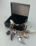 Belissima pulseira estilo corrente composta por sete berloques sendo : dente de javali , sabre e outros .