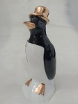 Escultura representando pinguim. Escultura em preto e branco com detalhes à ouro. Medindo 16 cm de altura.