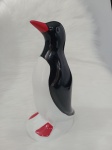 Pinguim em cerâmica nas cores preta e branca, com bico e as patas na cor vermelho . Medindo 23 cm de altura .