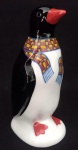Escultura representando pinguim. Escultura em preto e branco em detalhes com cachecol em tom azul e amarelo. Medindo 14 cm de altura.