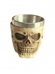 Copo de shot com tema de caveira em resina e interior em inox. Material resistente com excelente acabamento, rico em detalhes, produzido de modo semi artesanal. Medidas: Altura: 6 cm. Diâmetro: 5,5 cm. Capacidade: 60 ml.