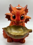 Incensário cascata em resina policromada, moldada como dragão baby na cor predominante laranja. Incenso é colocado na parte superior da cabeça com a fumaça exalando pelo nariz. Medidas: Altura 12cm x Largura 10cm x 11cm Profundidade.