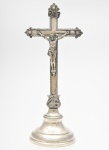 Antigo e raro Crucifixo de mesa em prata Brasileira, ricamente cinzelado, escrito ROMA, com Cristo em alto relevo, medindo 36,5 cm de altura, peso bruto 683 g. Brasil séc. XIX.