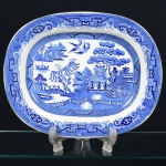 Antiga e rara Travessa Pombinho, em porcelana Inglesa, com motivos orientais, medindo 37 cm por 30 cm. Séc. XIX.