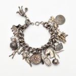 Joia de Crioula - Rara e importante Pulseira com 23 balangandãs em prata e diferente materiais, medindo 18 cm de comprimento. Bahia séc. XIX.