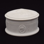 Pequeno Porta Joias em biscuit, em forma redonda, representando o Rei Luís XIV da França, medindo 5 cm de altura por 9 cm de diâmetro. França Séc. XIX.