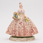GUIDO CACCIAPUOTI - Delicada Dama com Cesto de Flores em porcelana Italiana, assinada, medindo 29 cm de altura.