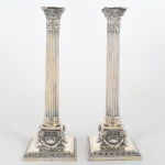 Magnifico par de Castiçais em prata Inglesa, contrastado, ricamente cinzelado, em forma de Colunas, medindo 32 cm de altura, pesando 516 g. Séc. XIX. No estado.