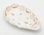 D. PEDRO II - SERVIÇO DO CASSINO FLUMINENSE - Raríssimo Covilhete em porcelana Velho Paris, borda decorada com guirlandas de flores em policromia e arabescos dourados entre frisos dourados, centro da caldeira com roseta dourada com ramos de flores em policromia, medindo 23,5 cm por 14 cm. França, séc. XIX. Pág. 228 do Livro "Louça da Aristocracia do Brasil", por Jenny Dreyfeus.