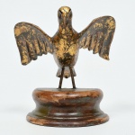 Antigo Divino em madeira com patina verde e dourada, sobre base, medindo 14 cm de altura. Séc. XIX.