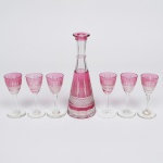 Baccarat - Belíssima Licoreira e seis taças em cristal Frances, na cor rubi, ricamente lapidada, medindo a garrafa 21 cm e as taças 11 cm. França séc. XIX. Falta a tampa.