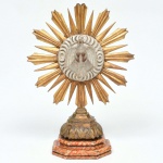 Antigo Ostensório em madeira policromada e dourada, tendo ao centro o Divino Espirito Santo, sobre base marmorizada, medindo 43 cm de altura. Séc. XIX.