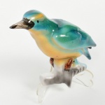 Escultura em porcelana, marcada, em forma de Pássaro, nas cores verde e amarelo, medindo 15 cm de altura.
