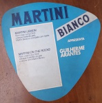 Leque Publicitário Vintage Martini Bianco  Campanha "Venha Viver" - Raro leque promocional em cartão rígido da marca italiana Martini Bianco. O item reproduz o rótulo clássico do vermute branco doce, destacando as medalhas de premiação e o brasão da Martini & Rossi - Torino.