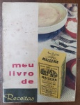 "Meu Livro de Receitas Maizena"  Edição Histórica Original  Anos 50/60 - Raro exemplar do livro oficial de receitas da Maizena (Duryea), um clássico da culinária e publicidade nacional. A capa apresenta uma composição fotográfica "mid-century" com a icônica caixa amarela da Maizena em destaque, acompanhada de elementos de mesa posta (talheres e tigela de louça).