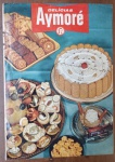 Raro Livreto de Receitas Vintage "Delícias Aymoré"  Original Anos 60/70 -  "Delícias Aymoré", uma publicação promocional vintage da icônica marca de biscoitos Aymoré, provavelmente lançada nas décadas de 1960 ou 1970. Trata-se de uma peça de ephemera publicitária muito valiosa para colecionadores, pois registra a era de ouro dos biscoitos finos e das receitas elaboradas com bolachas no Brasil.