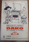 Raro Receituário Vintage DAKO - "De Fôrno e Fogão" - Década de 50/60 -  Receituário Dako, distribuído pela icônica marca de fogões que marcou gerações. O livreto apresenta uma ilustração charmosa em estilo "retrô" na capa, mostrando uma menina em um banquinho interagindo com um fogão da época, além de destacar a parceria com a "Tubos Bundy".