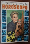 Revista Horóscopo Nº 10 (Anos 60) - Bloch Editores - Astrologia Vintage - Este exemplar original da revista Horóscopo é um registro fascinante do interesse popular pela astrologia em meados do século XX. A capa apresenta uma fotografia colorida de uma modelo segurando flores, emoldurada por ilustrações gráficas azuis dos signos do zodíaco.