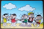 Cartões Postais promocionais Nestlé / Turma da Mônica (1995). A cena retrata um "Cabo de Guerra" onde a Mônica segura a corda com apenas uma mão e um sorriso, enquanto Cebolinha, Franjinha e Cascão fazem um esforço enorme do outro lado.