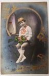 cartão-postal fotográfico antigo, datado provavelmente das décadas de 1910 ou 1920, apresentando uma estética infantil clássica da época. O uso de douração em relevo e a colorização manual o tornam uma peça decorativa muito charmosa.