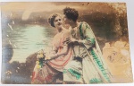 Raro Cartão Postal Antigo "Cena Clássica"  Estética Greco-Romana  Fotografia Colorizada à Mão (Circa 1900-1915)Raríssimo cartão postal de estúdio que evoca a antiguidade clássica. A cena retrata um casal em trajes que remetem à Grécia ou Roma Antiga, uma temática recorrente na cartofilia artística da Belle Époque, influenciada pelas artes plásticas e pelo teatro da época.
