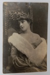 Antigo Cartão Postal Artístico  Retrato Feminino de Gala  Fotografia de Estúdio Europeia (Circa 1900-1910)Exemplar original da era dourada da cartofilia, apresentando um retrato clássico de uma jovem em traje de gala. A composição destaca a sofisticação da época, com foco na iluminação dramática e na moda aristocrática do início do século XX.