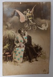 Antigo Cartão Postal "Fantasy"  Casal e Cupido em Carruagem Alada  Fotomontagem Colorizada (Circa 1900-1915)Raríssimo exemplar de fotomontagem artística do início do século XX. A peça une o romantismo clássico a elementos fantásticos, criando uma cena que parece saída de um sonho ou de uma peça teatral da Belle Époque.