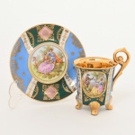 PORCELANA, uma (1) xícara para café, ornamentação policromada representando cena de galanteio inclusive no fundo da xícara, faixas policromadas com generosos arremates a ouro, base quadrupla, alças curvilíneas, marca de manufatura ou decoradora G. E. B., possivelmente alemã, ideal para coleção de cristaleira, vide foto.