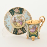 PORCELANA, uma (1) xícara para café, ornamentação policromada representando cena de galanteio inclusive no fundo da xícara, faixas policromadas com generosos arremates a ouro, base quadrupla, alças curvilíneas, marca de manufatura ou decoradora G. E. B., possivelmente alemã, ideal para coleção de cristaleira, vide foto.