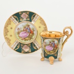 PORCELANA, uma (1) xícara para café, ornamentação policromada representando cena de galanteio inclusive no fundo da xícara, faixas policromadas com generosos arremates a ouro, base quadrupla, alças curvilíneas, marca de manufatura ou decoradora G. E. B., possivelmente alemã, ideal para coleção de cristaleira, vide foto.