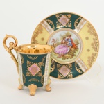 PORCELANA, uma (1) xícara para café, ornamentação policromada representando cena de galanteio inclusive no fundo da xícara, faixas policromadas com generosos arremates a ouro, base quadrupla, alças curvilíneas, marca de manufatura ou decoradora G. E. B., possivelmente alemã, ideal para coleção de cristaleira, vide foto.