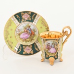 PORCELANA, uma (1) xícara para café, ornamentação policromada representando cena de galanteio inclusive no fundo da xícara, faixas policromadas com generosos arremates a ouro, base quadrupla, alças curvilíneas, marca de manufatura ou decoradora G. E. B., possivelmente alemã, ideal para coleção de cristaleira, vide foto.