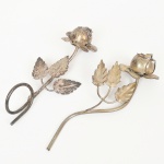 ESCULTURAS, duas (2) representando rosas, confeccionadas em metal prateado, medindo em média 13 cm comprimento, sinais de uso, vide foto