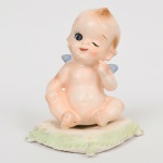 BISCUIT, uma (1) escultura representando anjo em cima de uma almofada, marca NAPCOWARE, modelo C6350, Made in Japan, medindo 11 cm altura, vide foto.