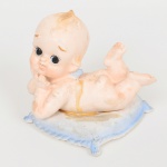 BISCUIT, uma (1) escultura representando anjo em cima de uma almofada, sem a marca do fabricante NAPCOWARE, modelo C6350, Made in Japan, medindo 8 cm altura, quebrado e colado, vide foto.