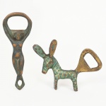 BRONZE, dois (2) abridores de garrafas distintos: 1 figurativo representando mulher nua; 1 animalista representando burrico, medindo o maior 9 cm, vide foto.