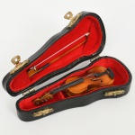 COLECIONISMO, uma (1) miniatura de violino, confeccionado em madeira e outros materiais, acompanham arco e estojo, medindo 14,5 cm comprimento, vide foto.