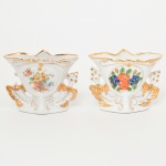 PORCELANA, dois (2) pequenos vasos floreiros, ornamentação floral policromada, arremates a ouro, um deles com quebrado em uma das laterais, marcado em cavo em um deles VIEIRA DE CASTRO (Rio de Janeiro 1939 a 1979), medindo 8 cm altura, sinais de uso, vide foto.