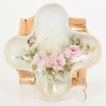 PORCELANA, um (1) cinzeiro, pintado a mão com rosas em policromia, Atelier IOLANDA, arremates a ouro, marca PEDRO II, Rio de Janeiro (fundada em 1921 por Tinoco Machado, Industrial Carioca, que contava com auxiliares que vieram da tradicional Fábrica de Vista Alegre de Portugal, foi a primeira fábrica de porcelana autêntica em escala Industrial no Brasil, funcionou até a década de 80), medindo aproximadamente 14 cm diâmetro, sinais de uso, vide foto.