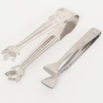 AÇO INOX, dois (2) pegadores de gelo distintos, o menor deles da marca BRINOX, medindo 13 cm e 15,5 cm comprimento, sinais de uso, vide foto