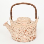 CERÂMICA, um (1) bule de chá, modelagem geometrizada com esmaltação vítrea, alça em aramado vergado recoberto com tresse em fibra vegetal, marcada em cavo na base BRASIL  Hand Made  ELGA, medindo 15,5 cm diâmetro e 20,5 cm altura ate a alça, sinais de uso, vide foto.