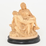 ESCULTURA, uma (1) representando PIETA baseada na obra do Grande Mestre Florentino MICHELANGELO BUONAROTTI (cuja original foi feita em mármore no ano de 1499, que atualmente se encontra na Basílica de São Pedro no Vaticano), confeccionada em resian na tonalidade marfim, base na tonalidade preta, assinada em cavo A. SANTINI, selo da marca na base, Made in Italy, medindo 11,5 cm altura, vide foto.