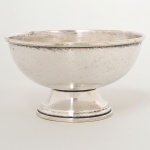 METAL PRATEADO, uma (1) pequena fruteira de pé baixo, formato de meia esfera, marca de manufatura não identificada no fundo, medindo 9 cm altura e 16 cm diâmetro, sinais de uso, vide foto.