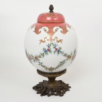 PORCELANA, um (1) imponente vaso, ornado com guirlandas de flores, pintadas a mão, arremates a ouro, base e pega da tampa em bronze vazado em elementos vegetalistas, medindo 34 cm altura, sinais de uso, vide foto.
