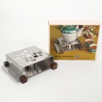 AÇO INOX, um (1) rechaud da marca HÉRCULES, design contemporâneo, detalhes em madeira, acondicionado na caixa e sem uso, ideal para presente, vide foto, medindo 20 x 16 x 6 cm.